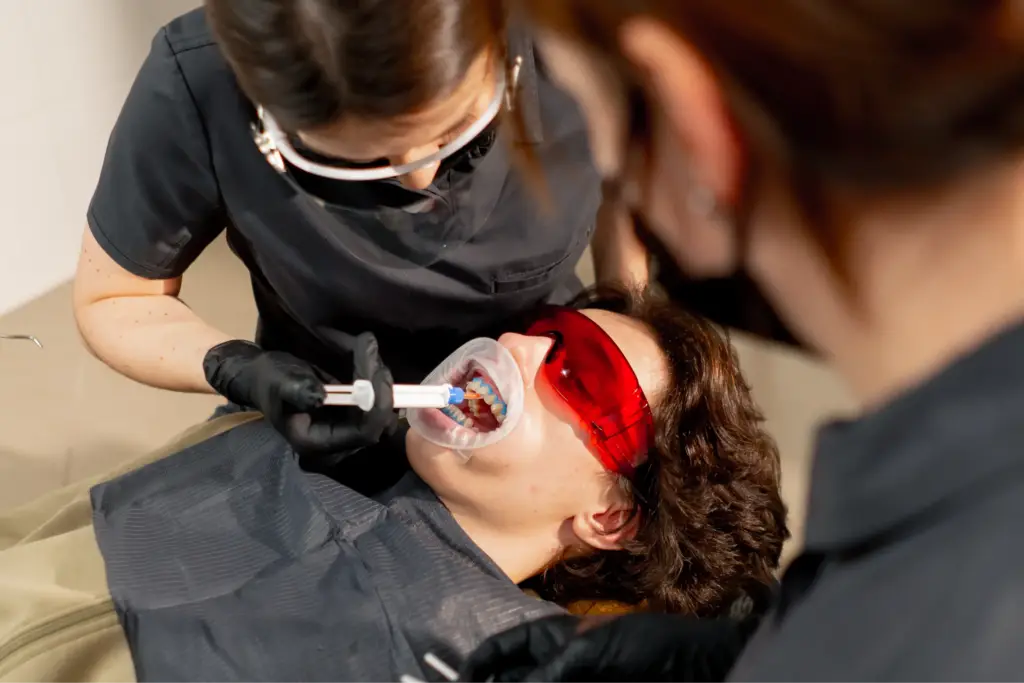 Student practising a teeth whitening treatment during hands-on training at Empire Medical Training Academy